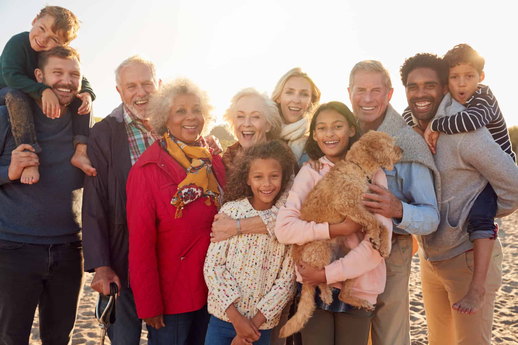 Portrait Of Multi-Generation Family Group With Dog On Winter Beach Vacation Portrait Of Multi-Generation Family Group With Dog On Winter Beach Vacation
