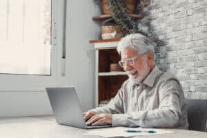 Man smiling while using a laptop
